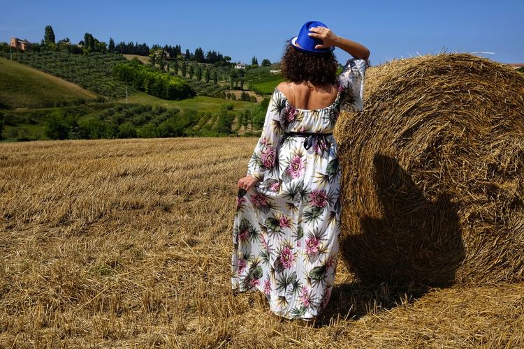 Beautiful woman between round bales