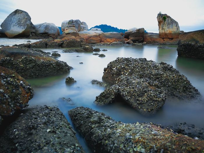 Rocks in sea against sky