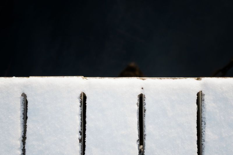 Close-up of text on snow covered metal during winter