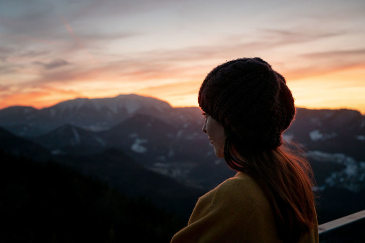 Portrait of woman looking at mountains against sky