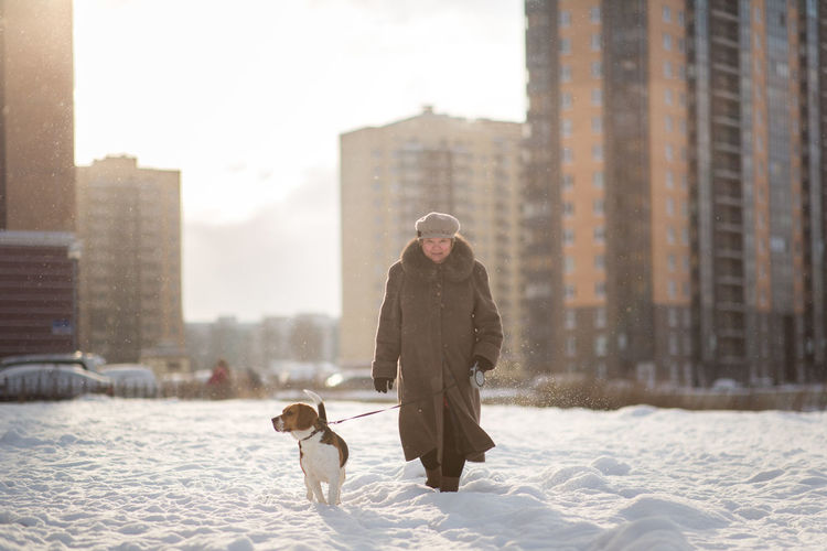 People walking on snow covered buildings in city