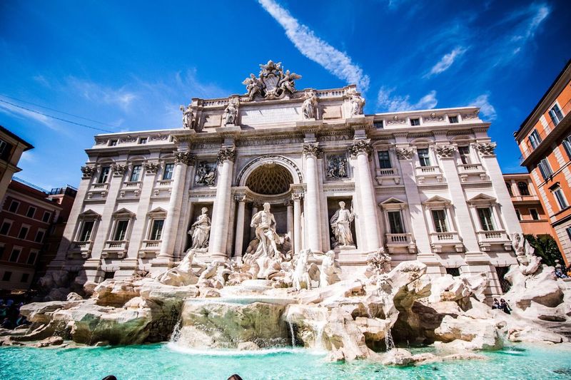 Low angle view of trevi fountain against blue sky