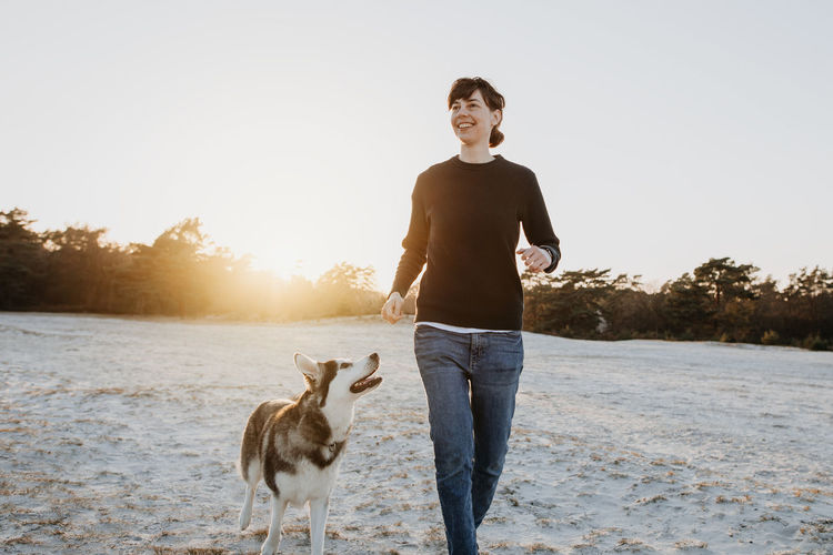 Smiling woman with dog standing outdoors