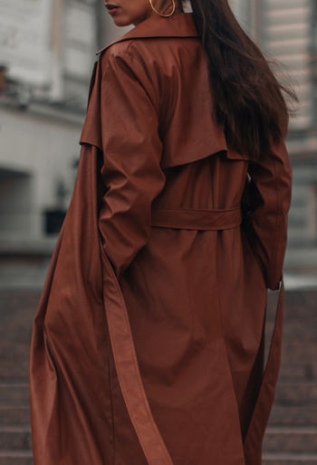 Autumn fashionable female outfit. stylish woman walking in brown coat outdoors. trendy modern 