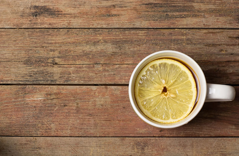 Close-up of lemon slice on wood