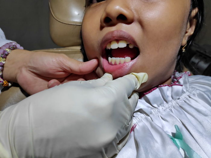Cropped hand of dentist examining patient