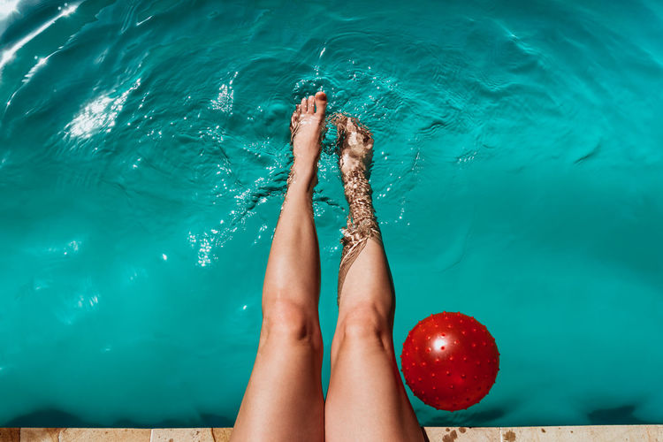 Low section of woman feet in swimming pool