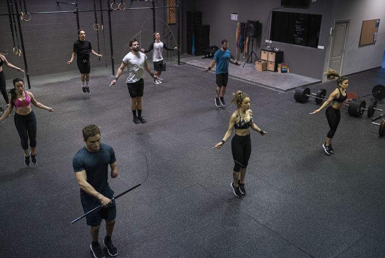 Group of people training with jumping rope in gym