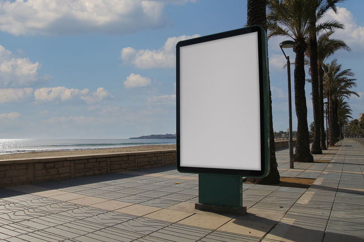 Footpath by sea against sky