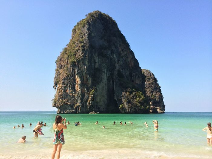 People enjoying ao phra nang beach against rock formation