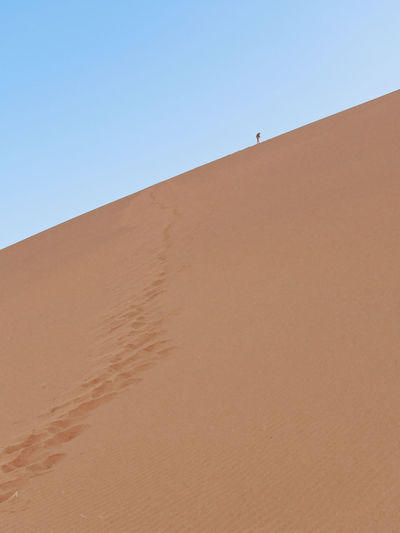 Sand dunes against clear sky