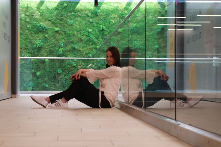 Woman sitting on glass window
