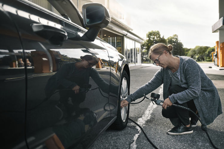 Woman filing air in car tire