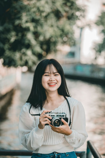 Portrait of smiling woman photographing