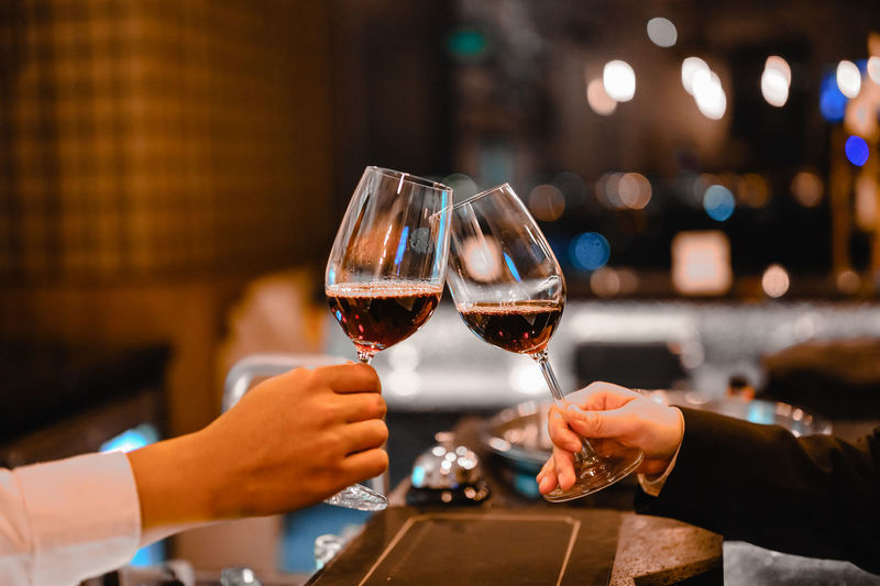 Cropped hands of man and woman toasting wine