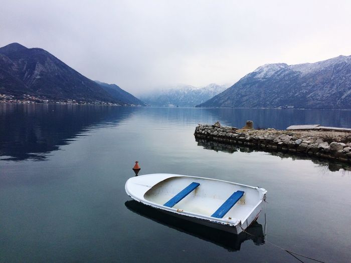 Boat floating on lake against sky