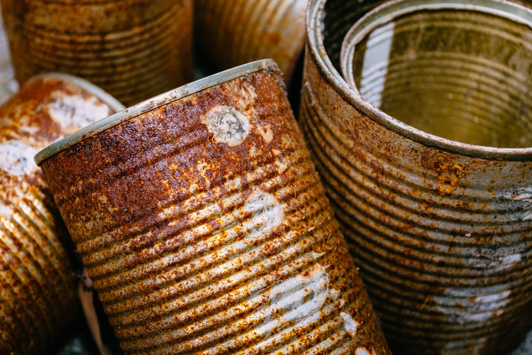 Close-up of rusty metallic containers on street