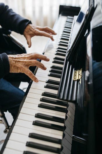 Crop view of senior man playing piano