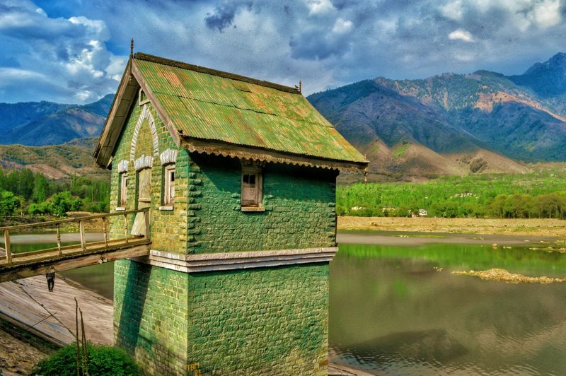 Built structure by lake against sky