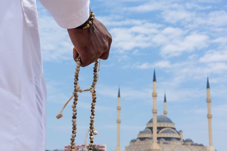 Close-up of hands holding religious beads