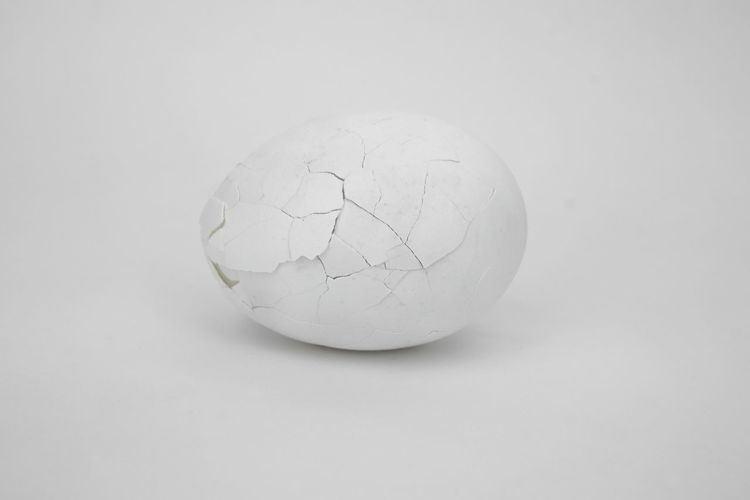 Close-up of broken glass over white background