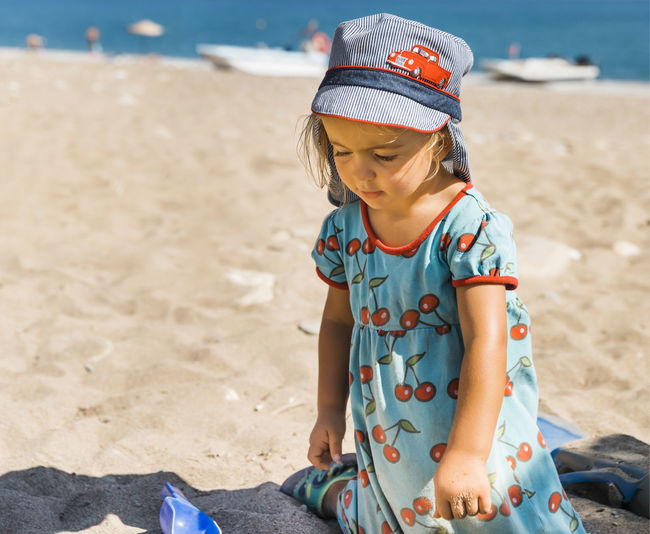 Cute girl playing in sand at beach