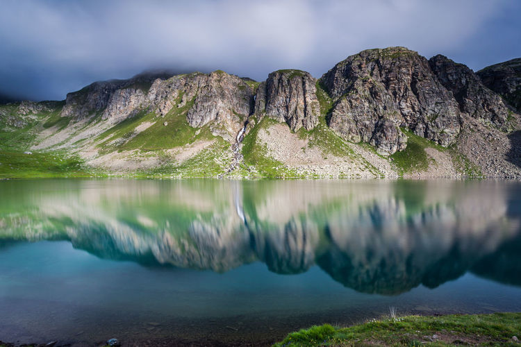 Reflection of mountains against sky on lake at gran paradiso national park