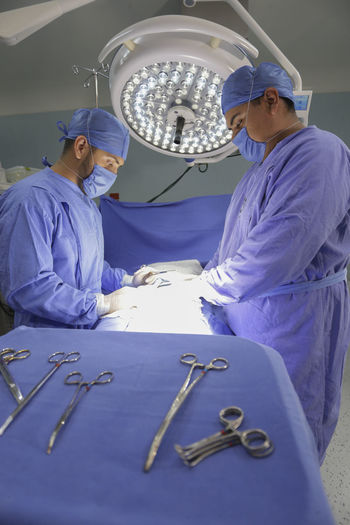 Side view of surgeons operating in room