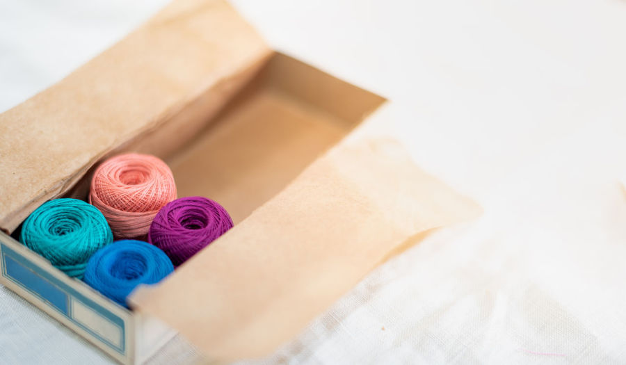 The multicolor embroidery thread roll using in the garment industry put on the classic paper box.
