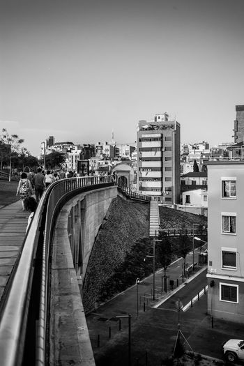Bridge in city against clear sky