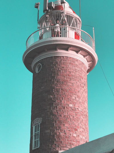Low angle view of woman standing on lighthouse