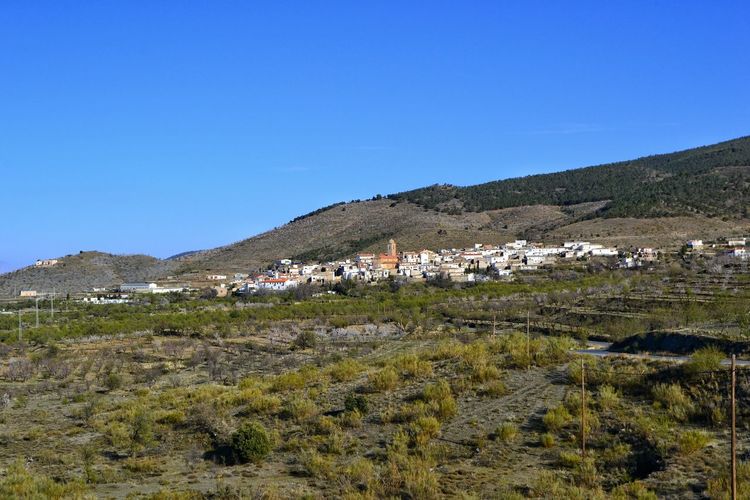 Scenic view of mountains against blue sky