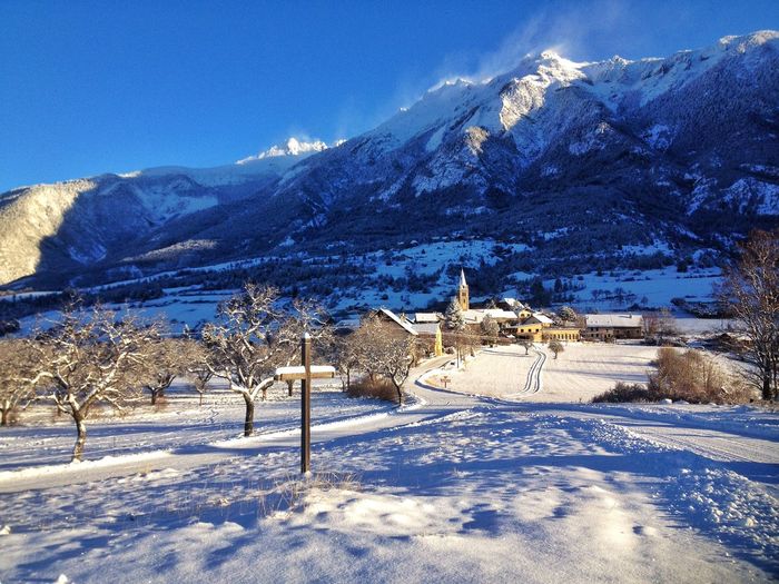 Scenic view of snowcapped mountains against blue sky