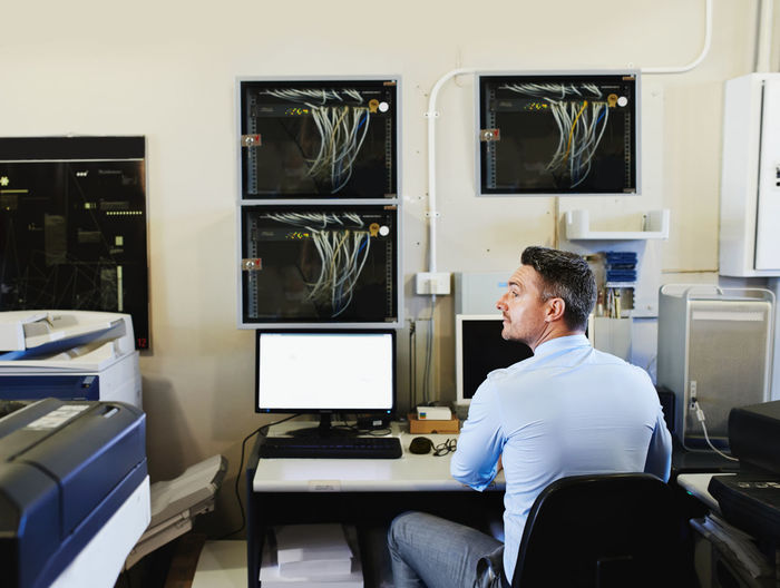 Rear view of man working at office