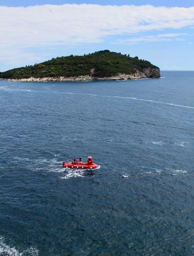 High angle view of red boat sailing in sea against sky
