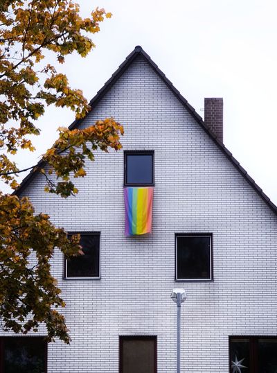 Exterior of house with rainbow flag hanging out of window