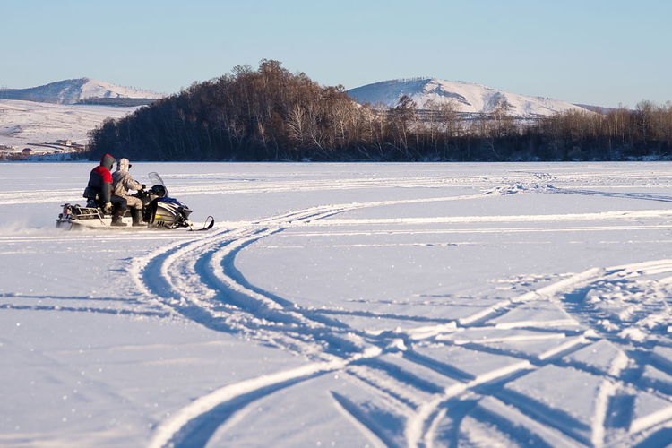 People skiing on snow covered landscape