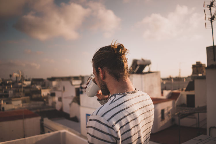 Man drinking coffee at balcony