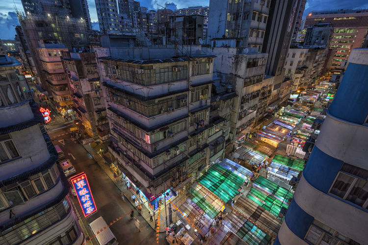 High angle view of illuminated street amidst buildings in city at dusk