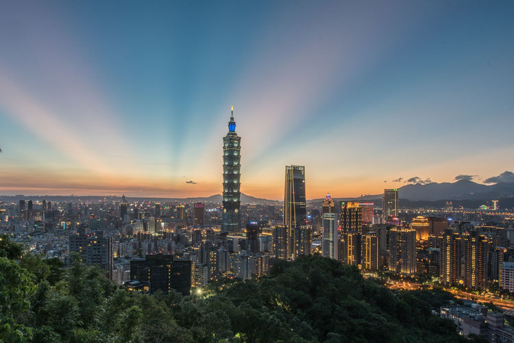 Illuminated buildings in city against sky