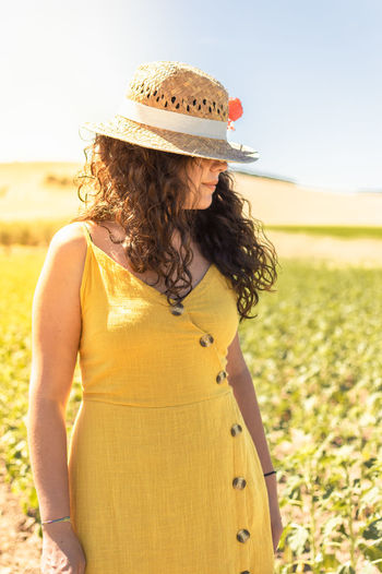 Midsection of woman wearing hat standing on field