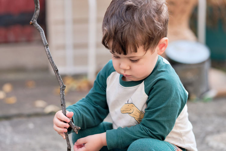 Portrait of cute boy sitting on swing at playground
