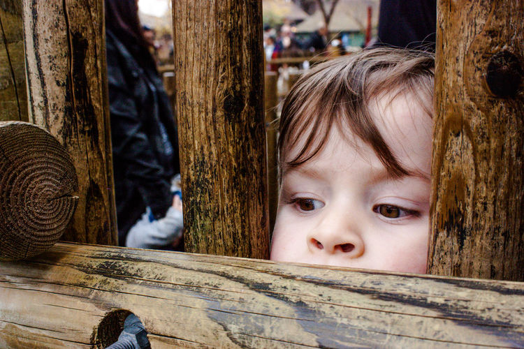 Cute boy peeking through fence