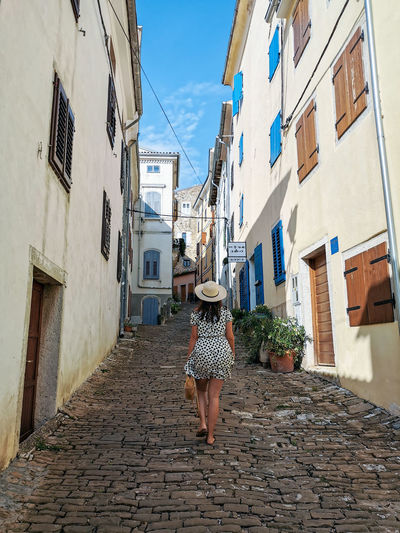 Young woman in dress in alley in old town. street, old buildings, travel, tourism, summer, vacation.