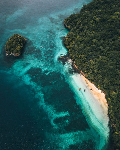 High angle view of islands covered by vegetation in with two boats in a small beach