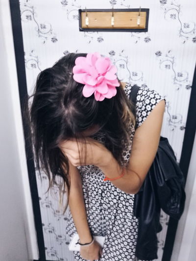 Girl standing by pink flowers