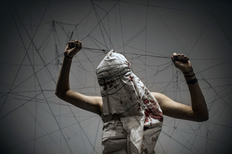 Rear view of man working on rope
