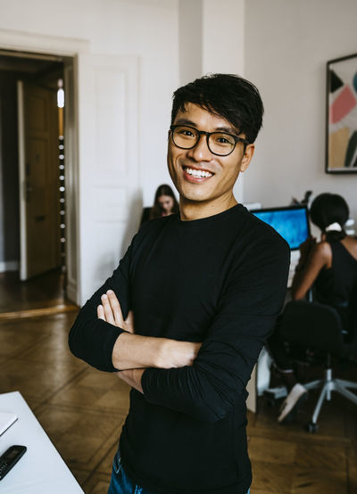 Portrait of smiling young man standing at home
