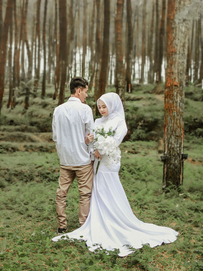 Bride standing in forest