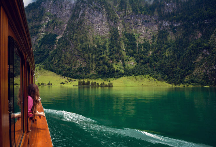 Woman in boat on lake against mountain